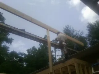 Carpenter setting a ridge beam over a new addition frame — Ice Dam Removal by Roofing Brothers in La Salle